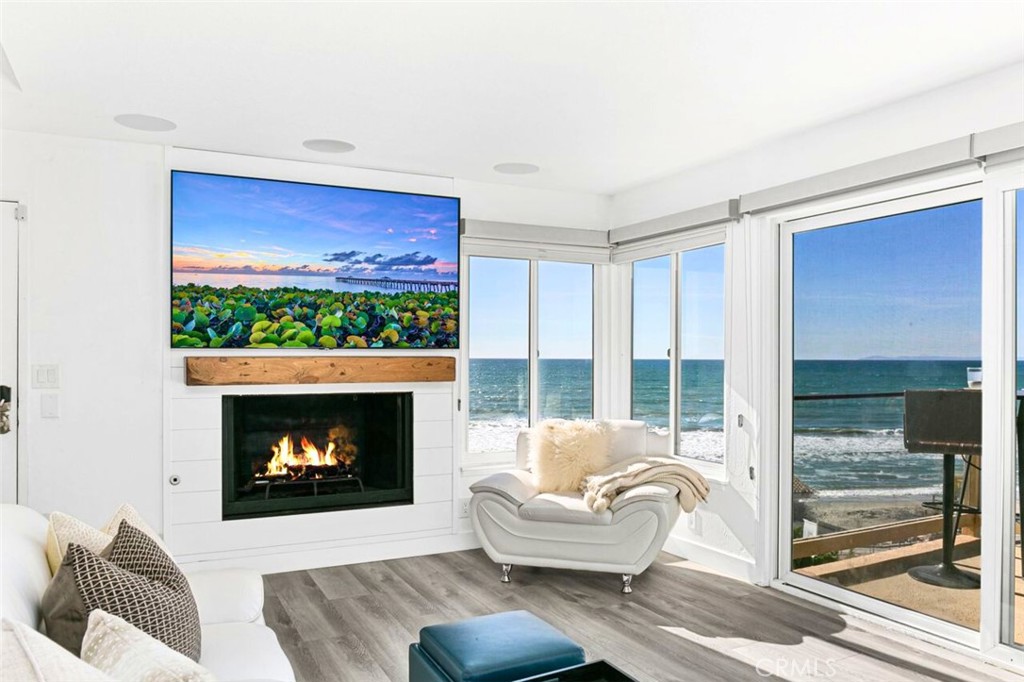 121 Boca De La Playa, Unit 1 San Clemente, CA 92672 - Photo 18 of 47 a living room with furniture a floor to ceiling window and a fireplace