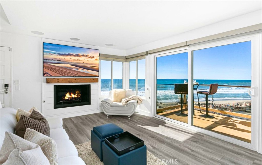 121 Boca De La Playa, Unit 1 San Clemente, CA 92672 - Photo 2 of 47 a living room with furniture two large windows and a fireplace