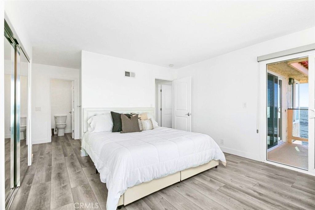 121 Boca De La Playa, Unit 1 San Clemente, CA 92672 - Photo 22 of 47 a bedroom with a bed and wooden floor