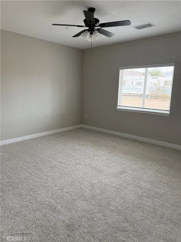 an empty room with a window and a fan