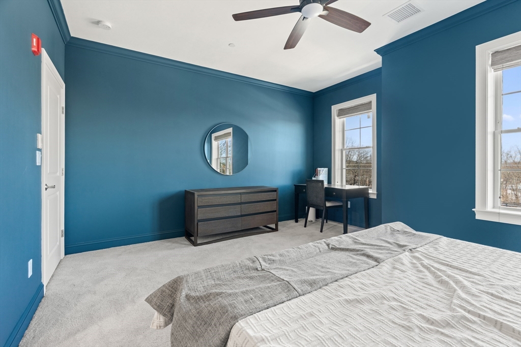 60 Coppersmith Way, Unit 407 Canton, MA 02021 - Photo 15 of 34 a bedroom with a bed and a chandelier