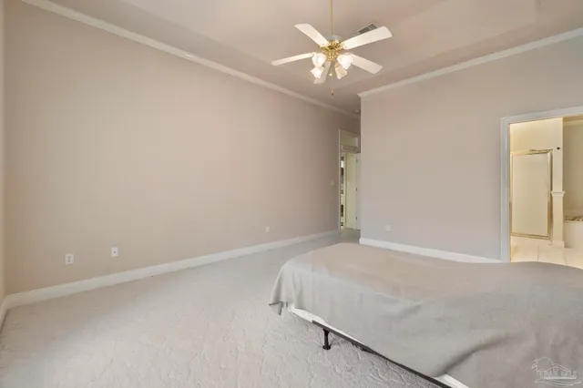 an empty room with a chandelier fan and windows