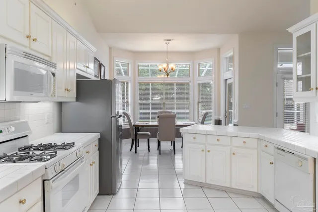 a kitchen with white cabinets and appliances
