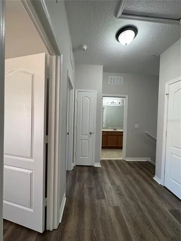 a view of a hallway with wooden floor and stairs