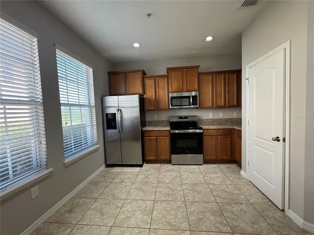 a kitchen with stainless steel appliances granite countertop a stove a sink and a refrigerator