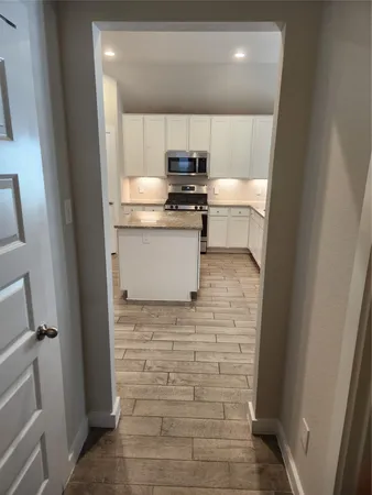 a kitchen with a refrigerator and a stove top oven
