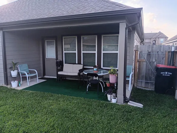 a backyard of a house with table and chairs
