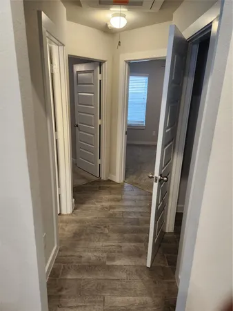 a view of a hallway with wooden floor and closet