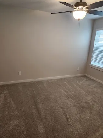 an empty room with a window and a fan