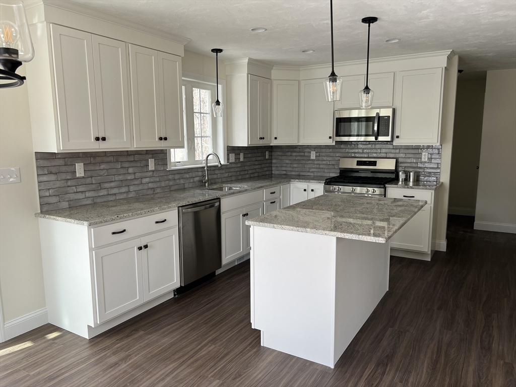 40 A Titus Way, Unit 40A Taunton, MA 02780 - Photo 3 of 16 a kitchen with stainless steel appliances granite countertop a stove a sink dishwasher a refrigerator and white cabinets with wooden floor