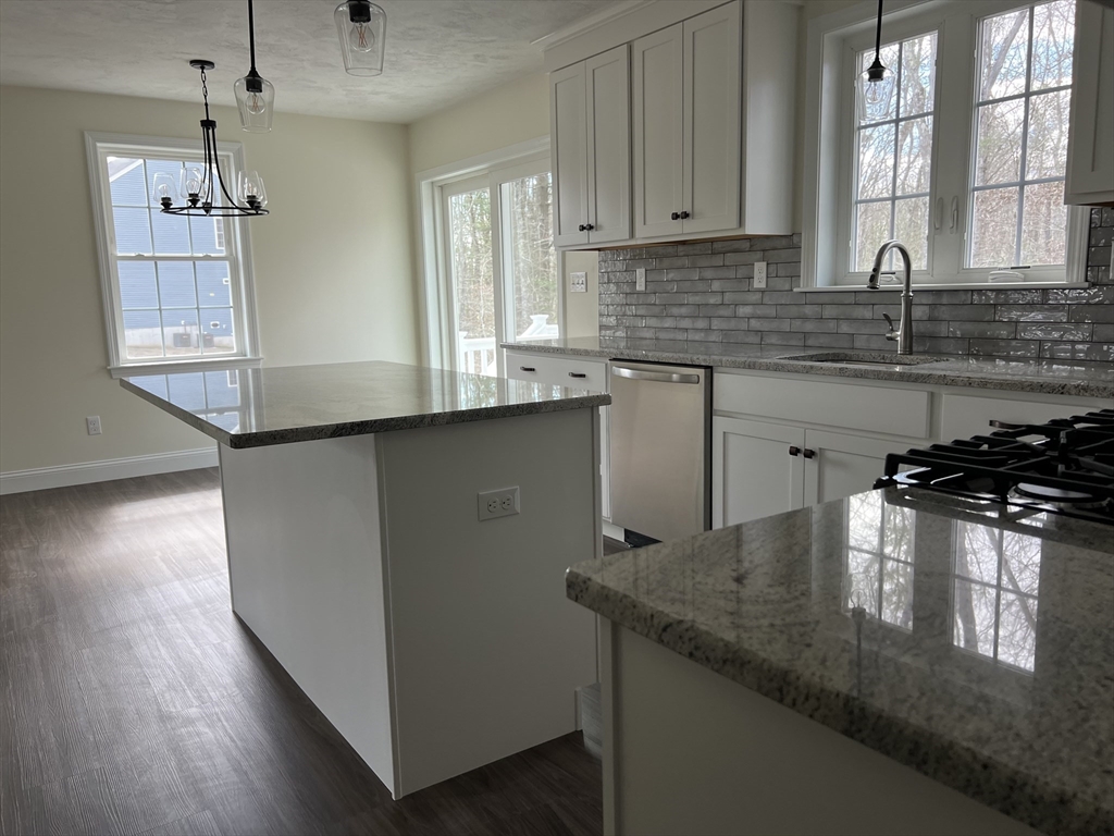 40 A Titus Way, Unit 40A Taunton, MA 02780 - Photo 4 of 16 a kitchen with stainless steel appliances granite countertop a sink a stove and a wooden floor