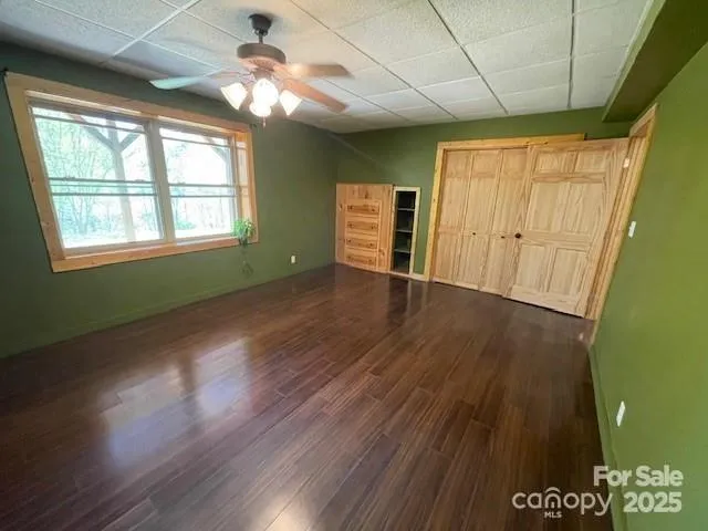 a view of an empty room with window and wooden floor