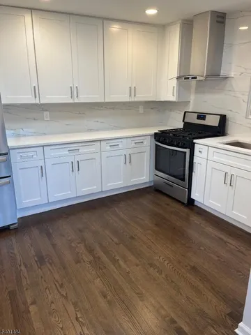 a kitchen with granite countertop white cabinets and white appliances