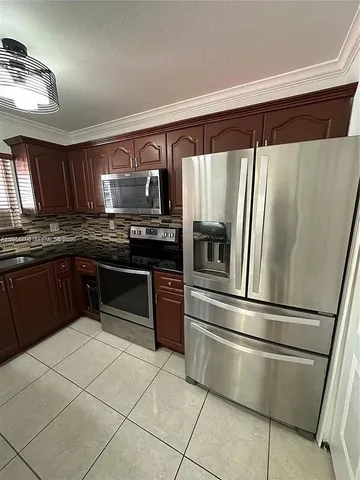 a kitchen with stainless steel appliances granite countertop a refrigerator sink and stove