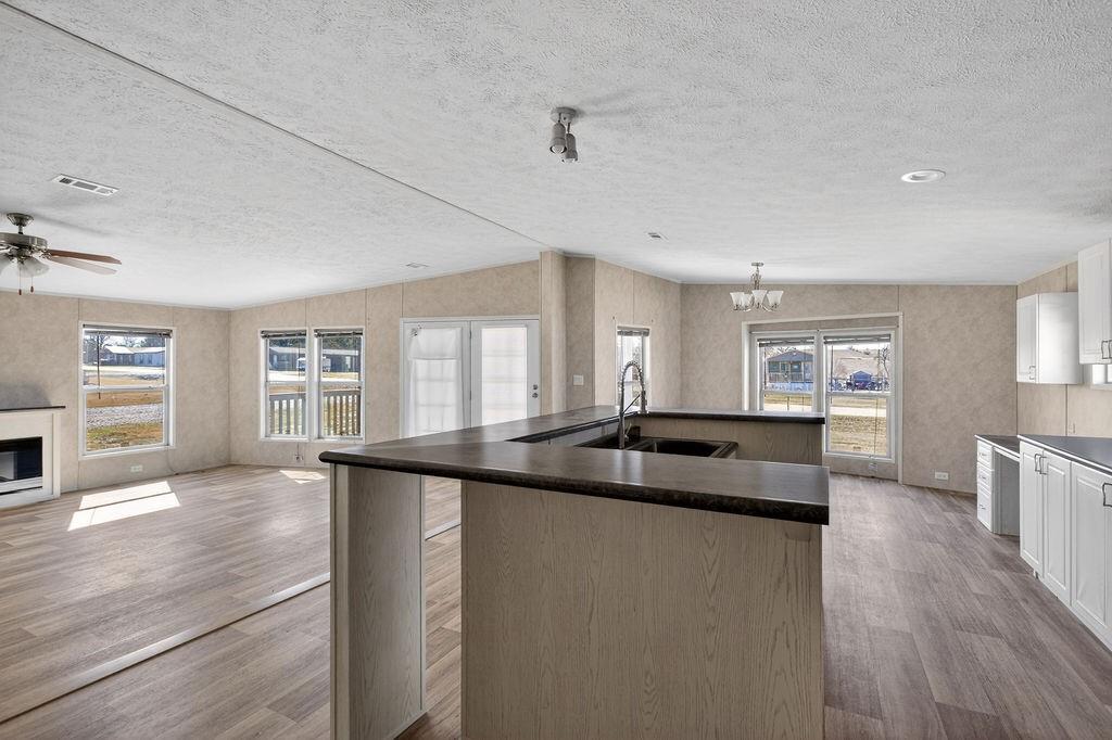 154 Firefly Drive Springtown, TX 76082 - Photo 12 of 39 a kitchen with granite countertop a sink and wooden cabinets
