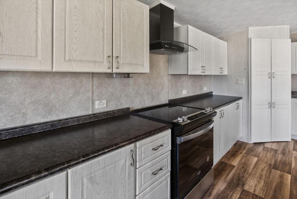154 Firefly Drive Springtown, TX 76082 - Photo 15 of 39 a kitchen with granite countertop white cabinets and black appliances