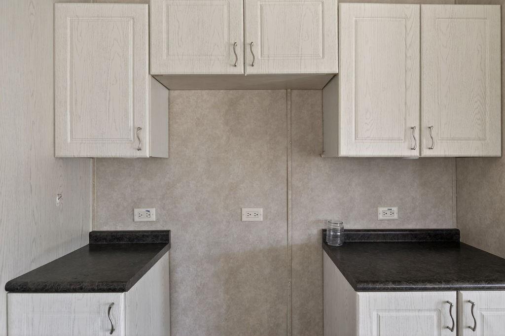 154 Firefly Drive Springtown, TX 76082 - Photo 17 of 39 a kitchen with granite countertop white cabinets and black appliances