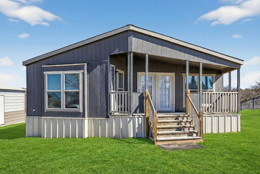 154 Firefly Drive Springtown, TX 76082 - Photo 2 of 39 a front view of a house with a garden