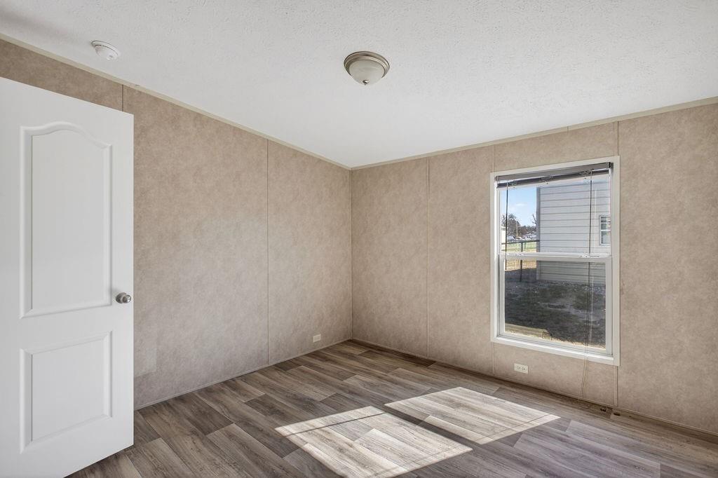 154 Firefly Drive Springtown, TX 76082 - Photo 32 of 39 a view of an empty room with wooden floor and a window