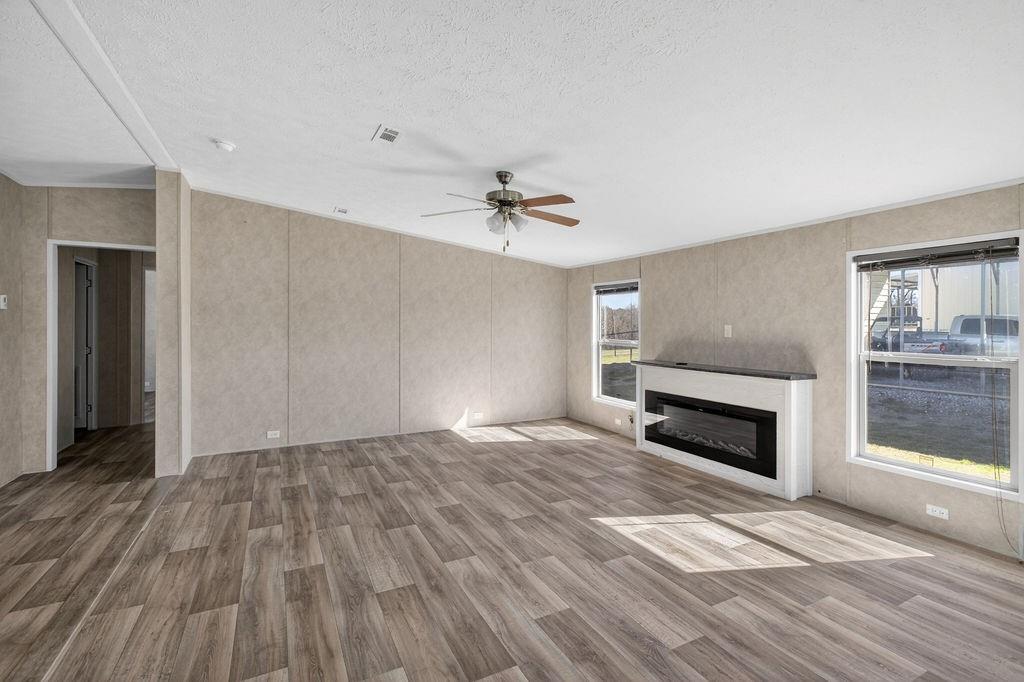154 Firefly Drive Springtown, TX 76082 - Photo 5 of 39 a view of empty room with wooden floor and fireplace