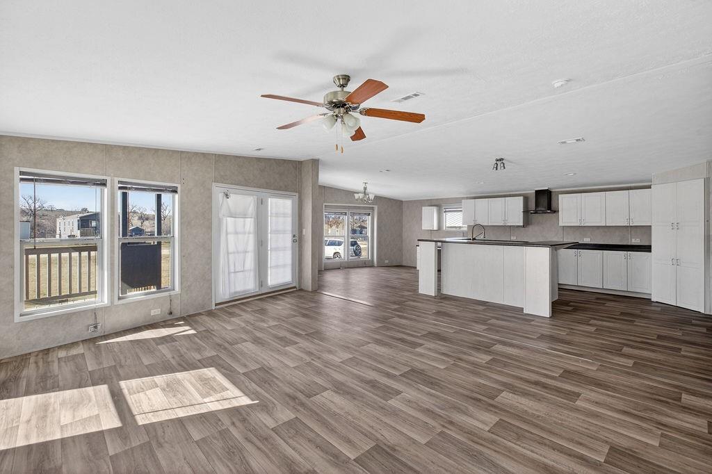 154 Firefly Drive Springtown, TX 76082 - Photo 7 of 39 a view of a kitchen with wooden floor and a ceiling fan