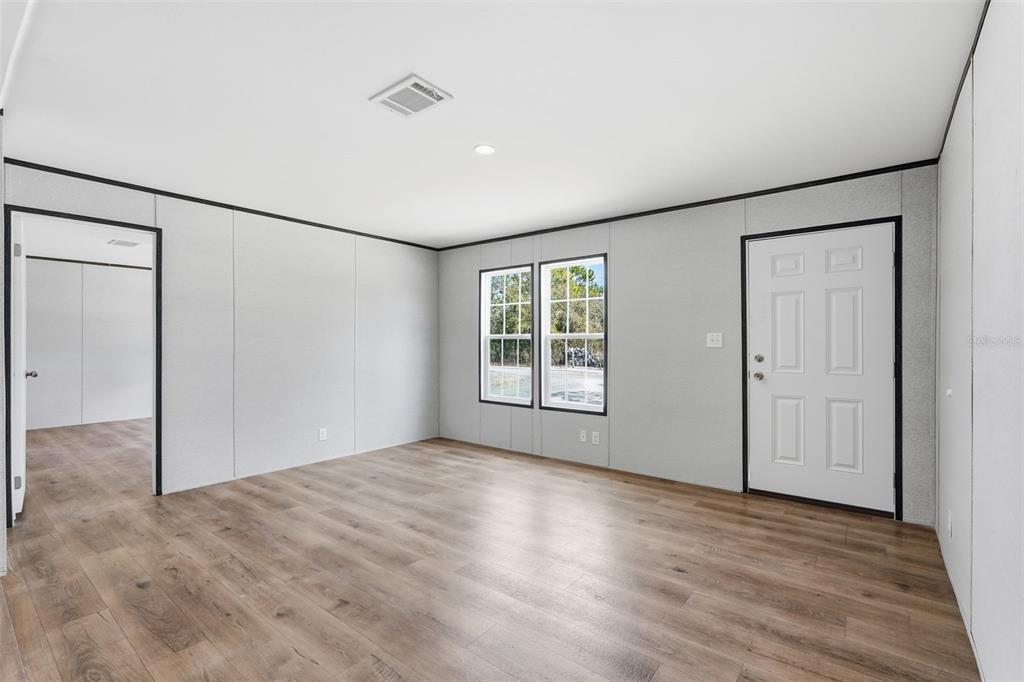16837 Lashua Drive Spring Hill, FL 34610 - Photo 14 of 37 an empty room with wooden floor and windows