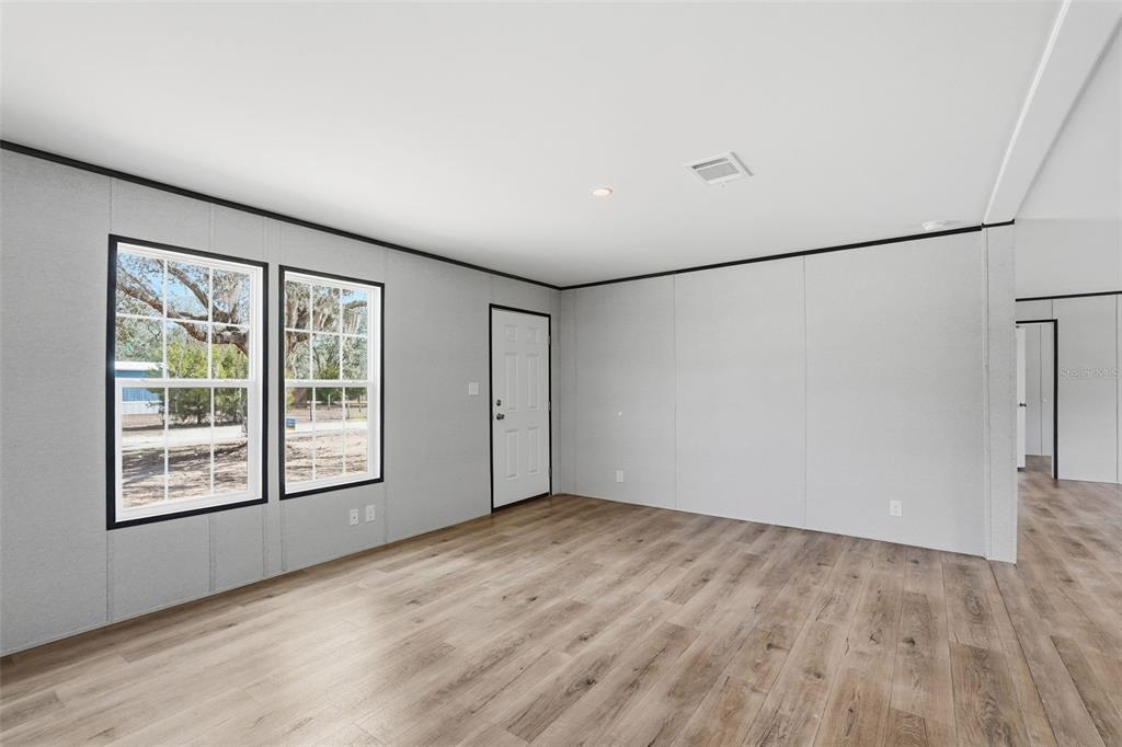 16837 Lashua Drive Spring Hill, FL 34610 - Photo 15 of 37 an empty room with wooden floor and windows