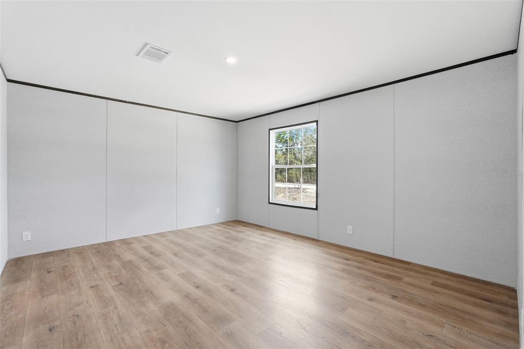 16837 Lashua Drive Spring Hill, FL 34610 - Photo 16 of 37 wooden floor in an empty room with a window