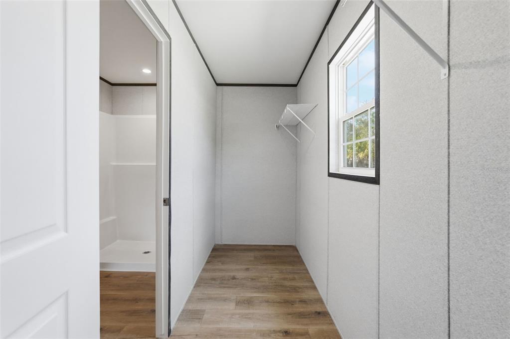 16837 Lashua Drive Spring Hill, FL 34610 - Photo 19 of 37 a view of a hallway with wooden floor and a bathroom