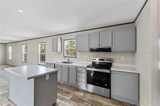 a kitchen with stainless steel appliances granite countertop a stove and a sink