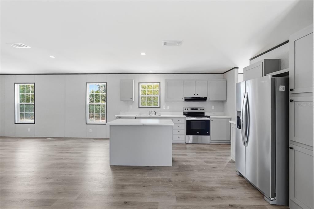 16837 Lashua Drive Spring Hill, FL 34610 - Photo 21 of 37 a kitchen with a refrigerator and a stove top oven