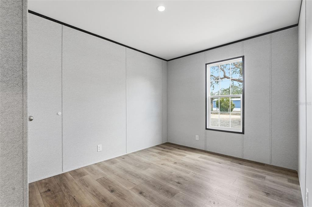 16837 Lashua Drive Spring Hill, FL 34610 - Photo 24 of 37 an empty room with wooden floor and windows