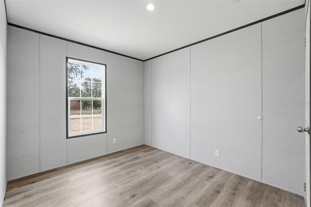 16837 Lashua Drive Spring Hill, FL 34610 - Photo 26 of 37 an empty room with wooden floor and windows