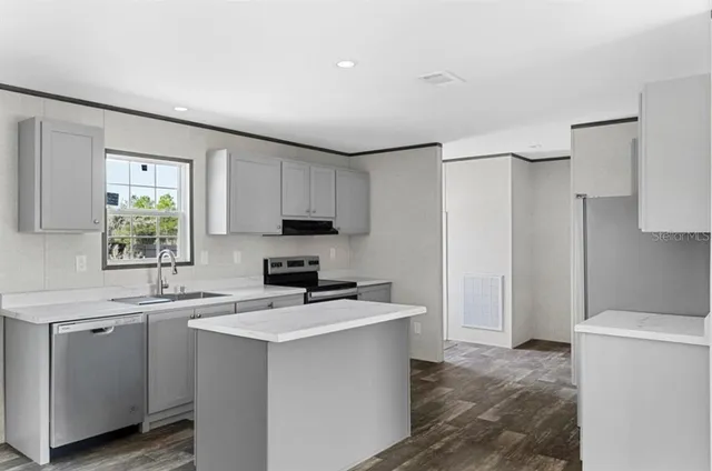 a kitchen that has a sink a stove and a refrigerator