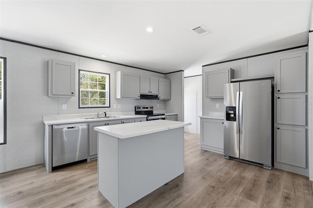 16837 Lashua Drive Spring Hill, FL 34610 - Photo 5 of 37 a kitchen with a refrigerator stove and sink