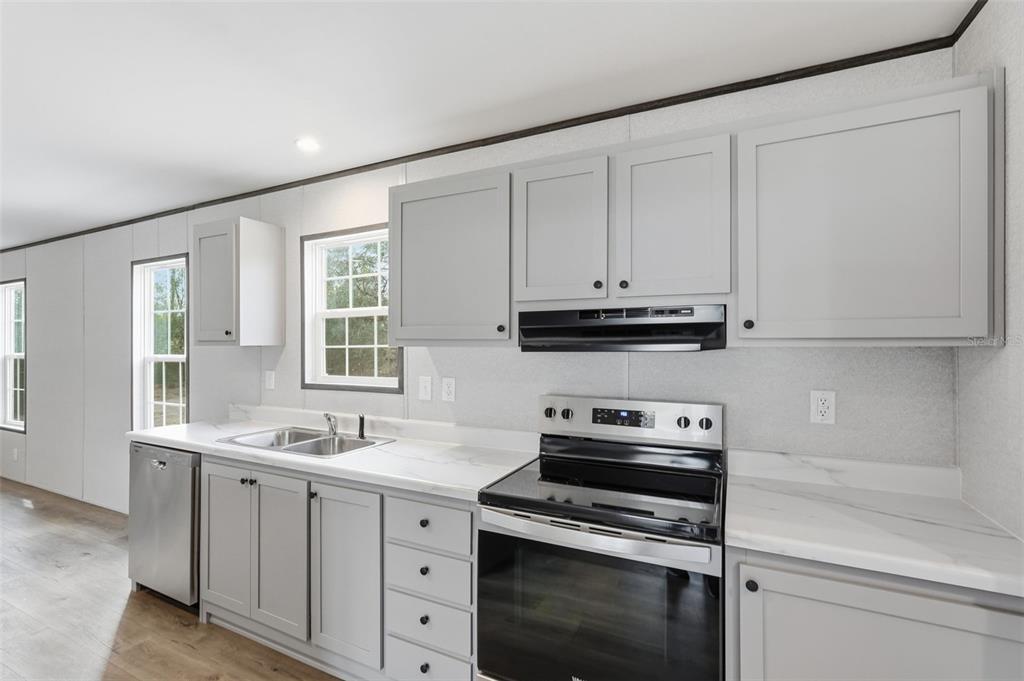16837 Lashua Drive Spring Hill, FL 34610 - Photo 8 of 37 a kitchen with white cabinets stainless steel appliances and sink