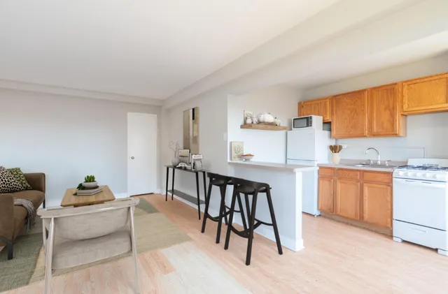 a living room with furniture a sink a window and stainless steel appliances
