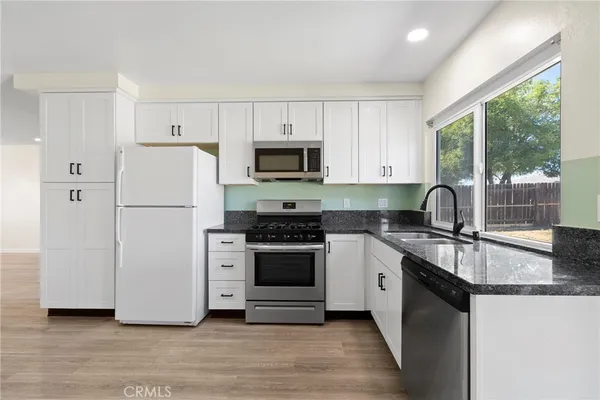 a kitchen with a refrigerator stove and white cabinets
