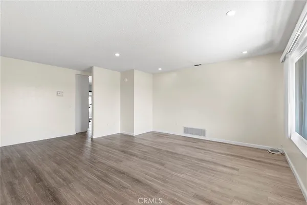 a view of an empty room with wooden floor
