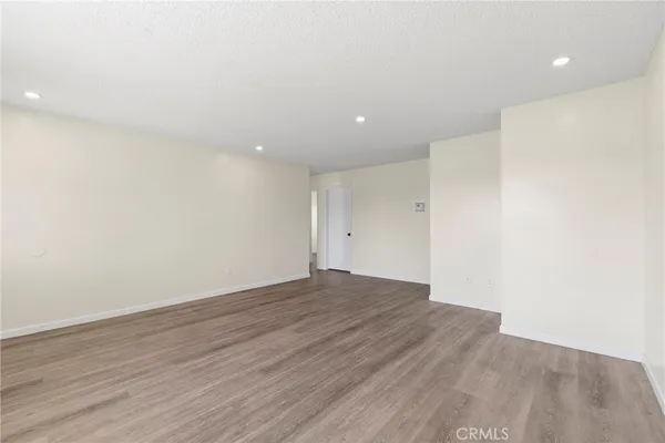 an empty room with wooden floor and ceiling fan