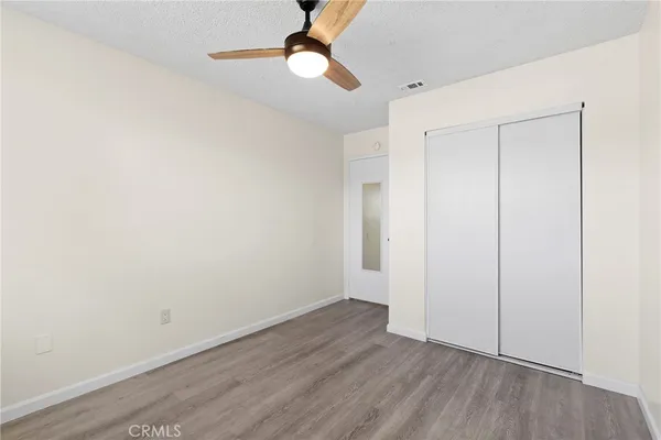 an empty room with a window and ceiling fan