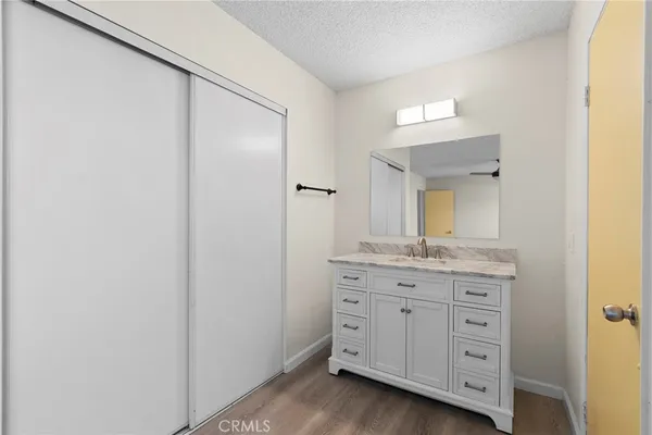 an empty room with wooden floor ceiling fan and windows