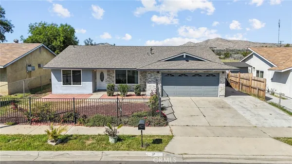 an aerial view of residential house with yard and mountain view in back