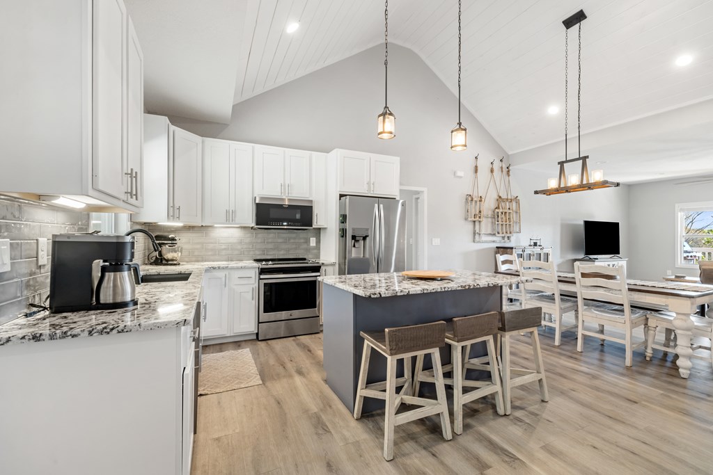 308 Mystic Ridge Blairsville, GA 30512 - Photo 7 of 68 a kitchen with stainless steel appliances kitchen island granite countertop a stove a sink a microwave a dining table and chairs with wooden floor