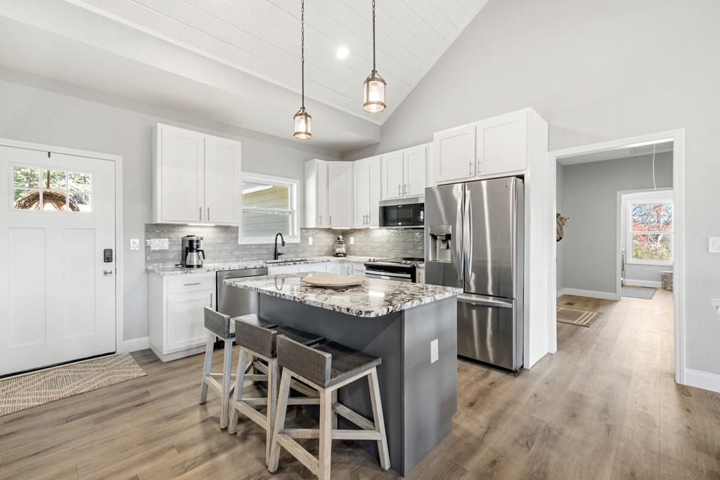 308 Mystic Ridge Blairsville, GA 30512 - Photo 9 of 68 a kitchen with stainless steel appliances granite countertop a refrigerator a stove a sink dishwasher a dining table and chairs with wooden floor