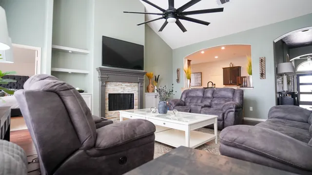 a living room with furniture a flat screen tv and a fireplace