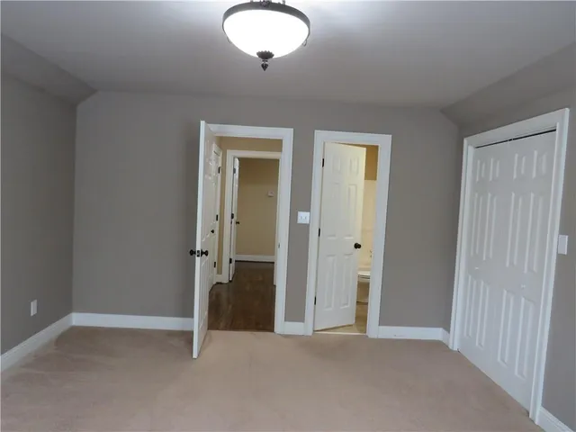 a bathroom with a granite countertop sink a toilet a mirror and shower