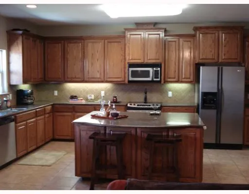 a kitchen with kitchen island granite countertop a sink stove and microwave