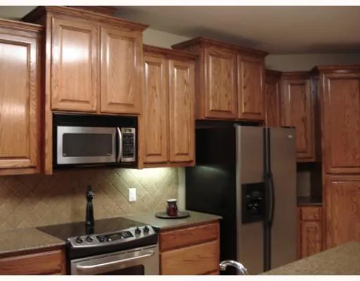 a kitchen with granite countertop a refrigerator stove and microwave