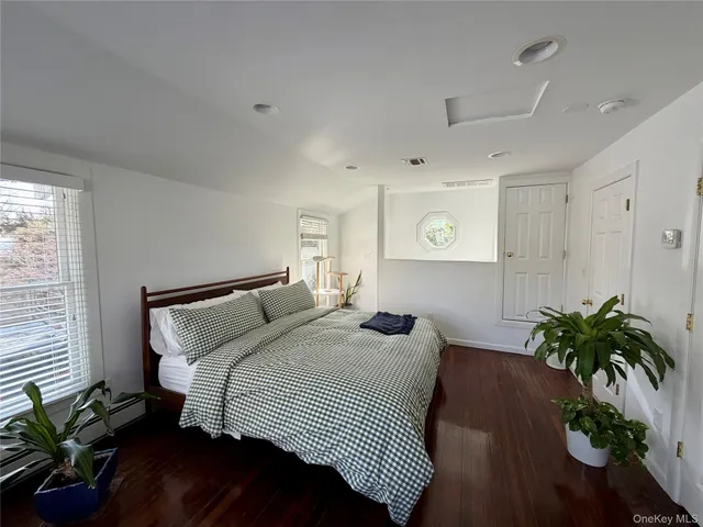 a bedroom with a bed and a potted plant